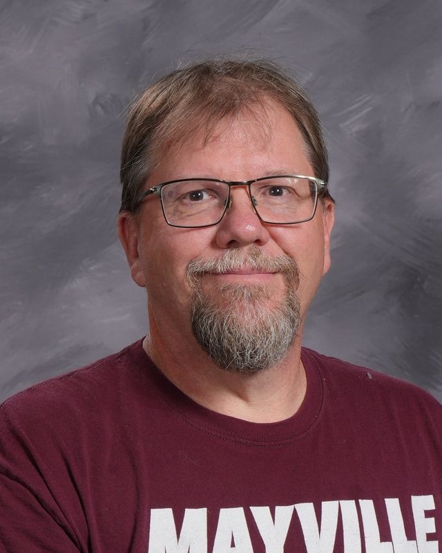 A man with glasses and a beard is smiling for the camera