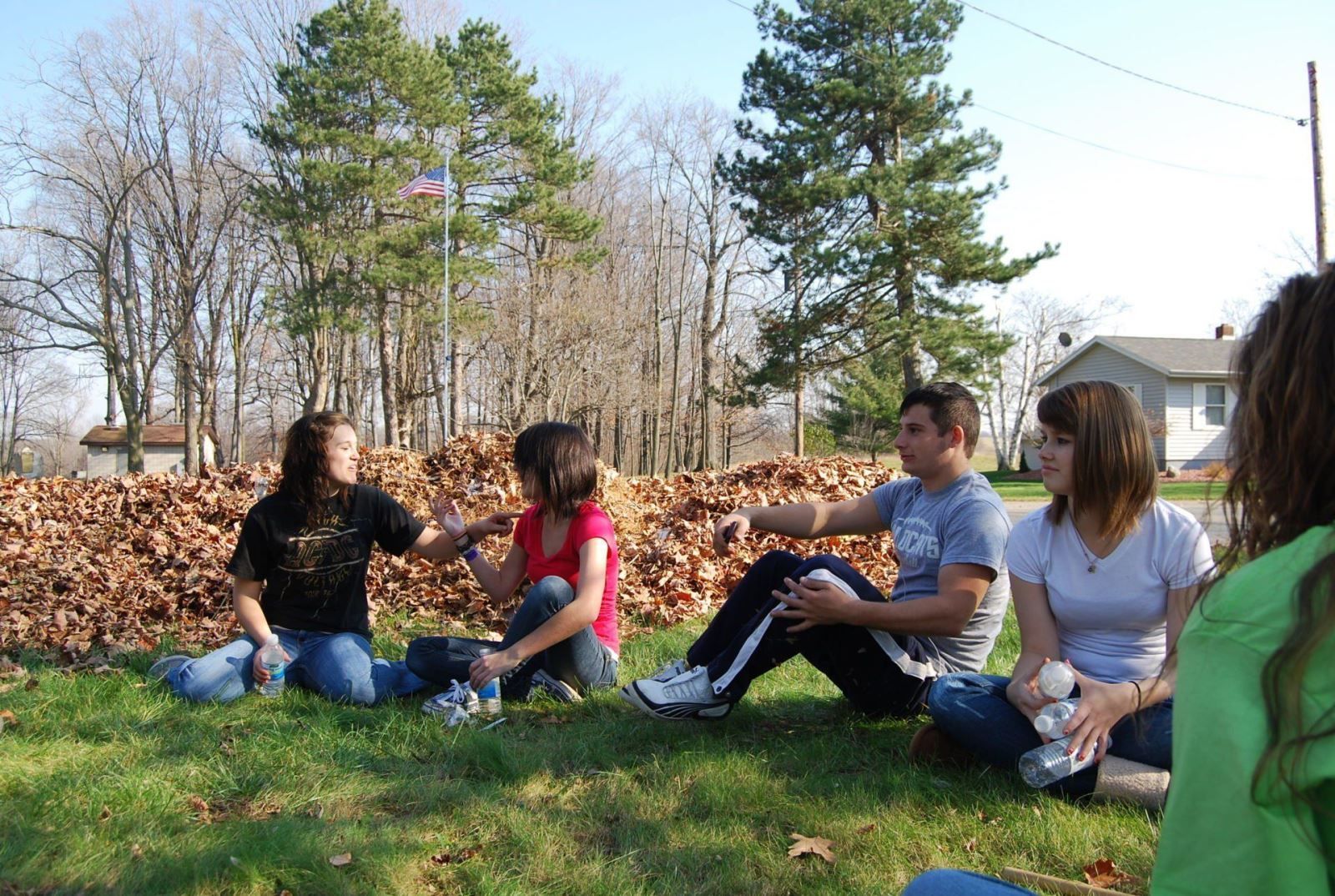 A group of people are sitting in a circle on the grass