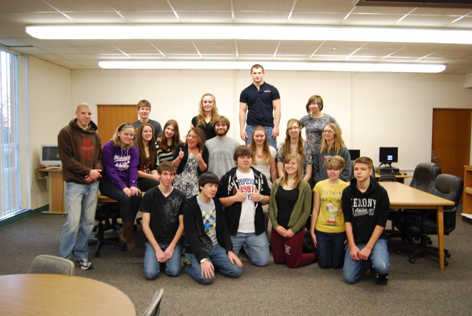 A group of young people posing for a picture in a room