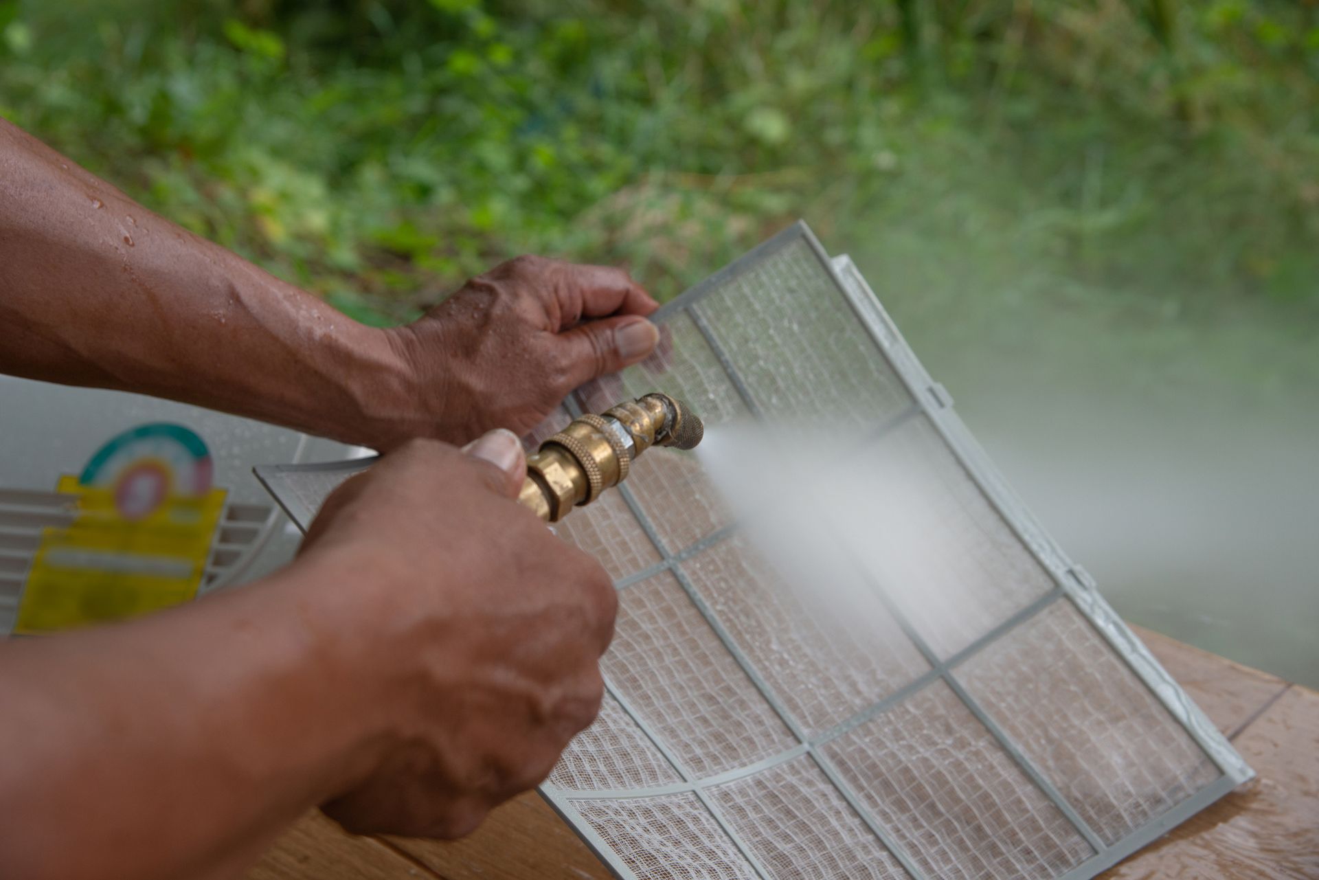 Technician is Spraying Water to Clean the Filter — Staten Island, NY — Cool Off HVAC