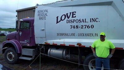 Man Standing Beside the Truck — Lock Haven, PA — Love Disposal, Inc. Man Standing Beside the Truck — Lock Haven, PA — Love Disposal, Inc.