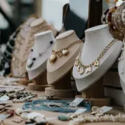 Display of hanging earrings on cards with boxed jewelry on a wooden table in a shop.