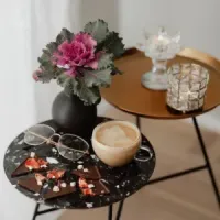 Display of hanging earrings on cards with boxed jewelry on a wooden table in a shop.