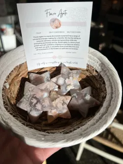Handheld wicker bowl filled with star-shaped stones and a small handwritten card behind them