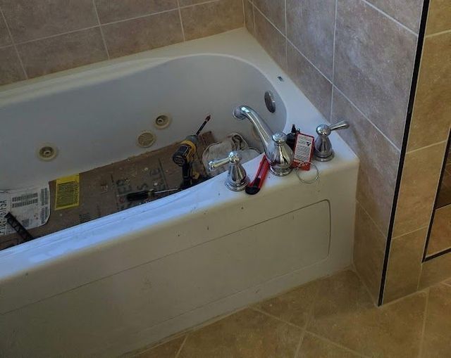 A bathtub is being remodeled in a bathroom.