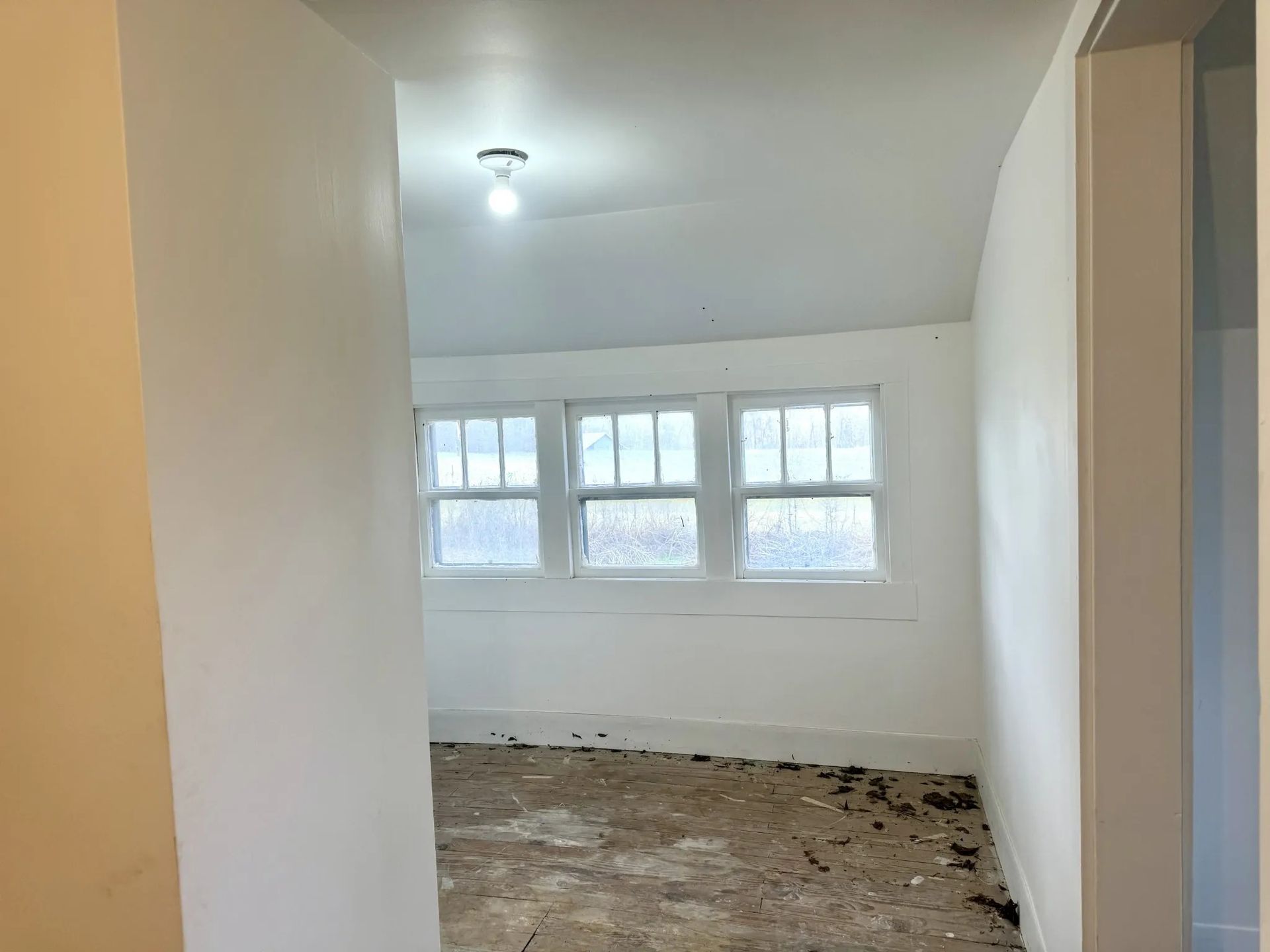 An empty room with a lot of windows and a light on the ceiling