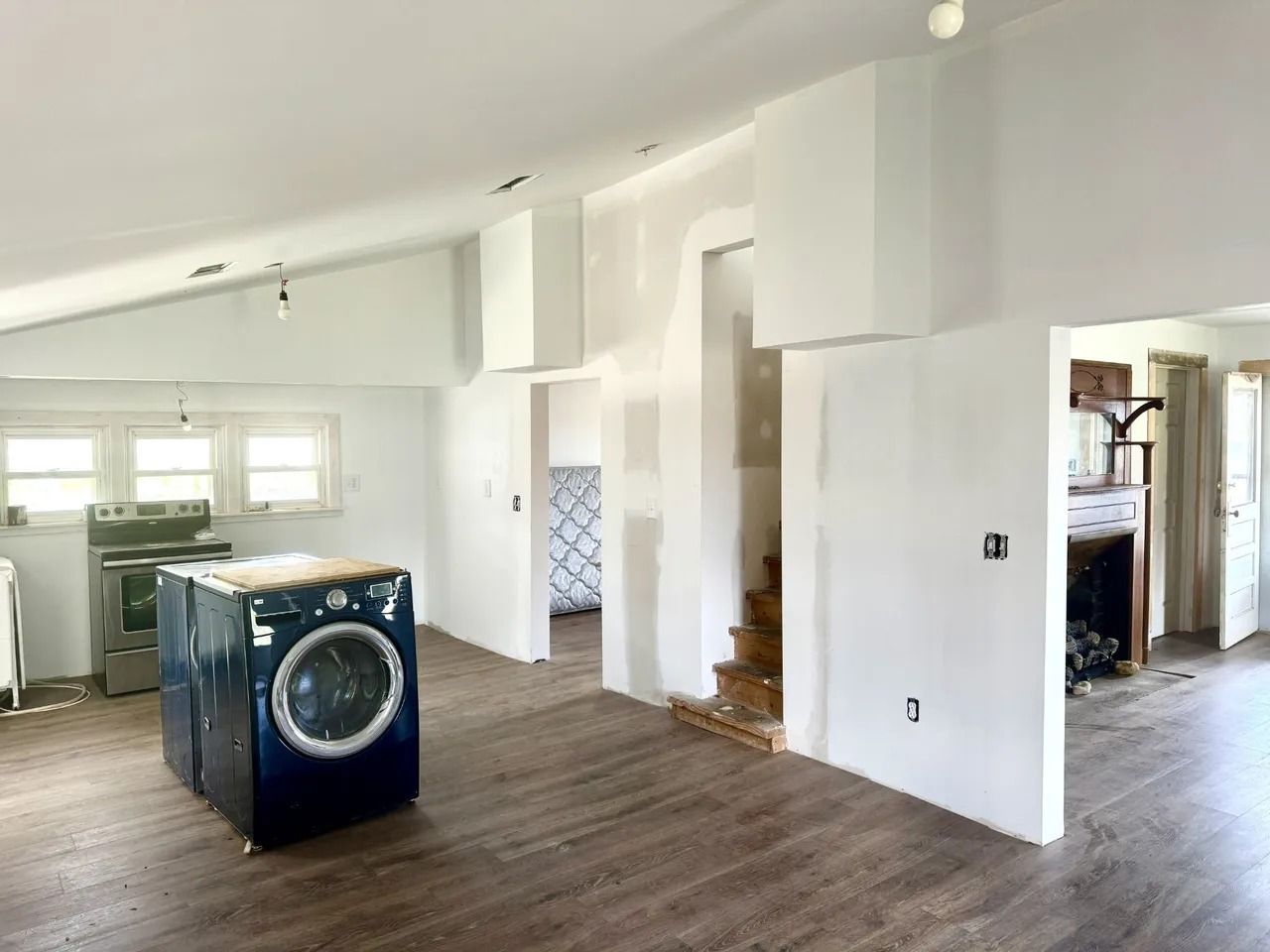 A washer and dryer are sitting in a room in a house under construction
