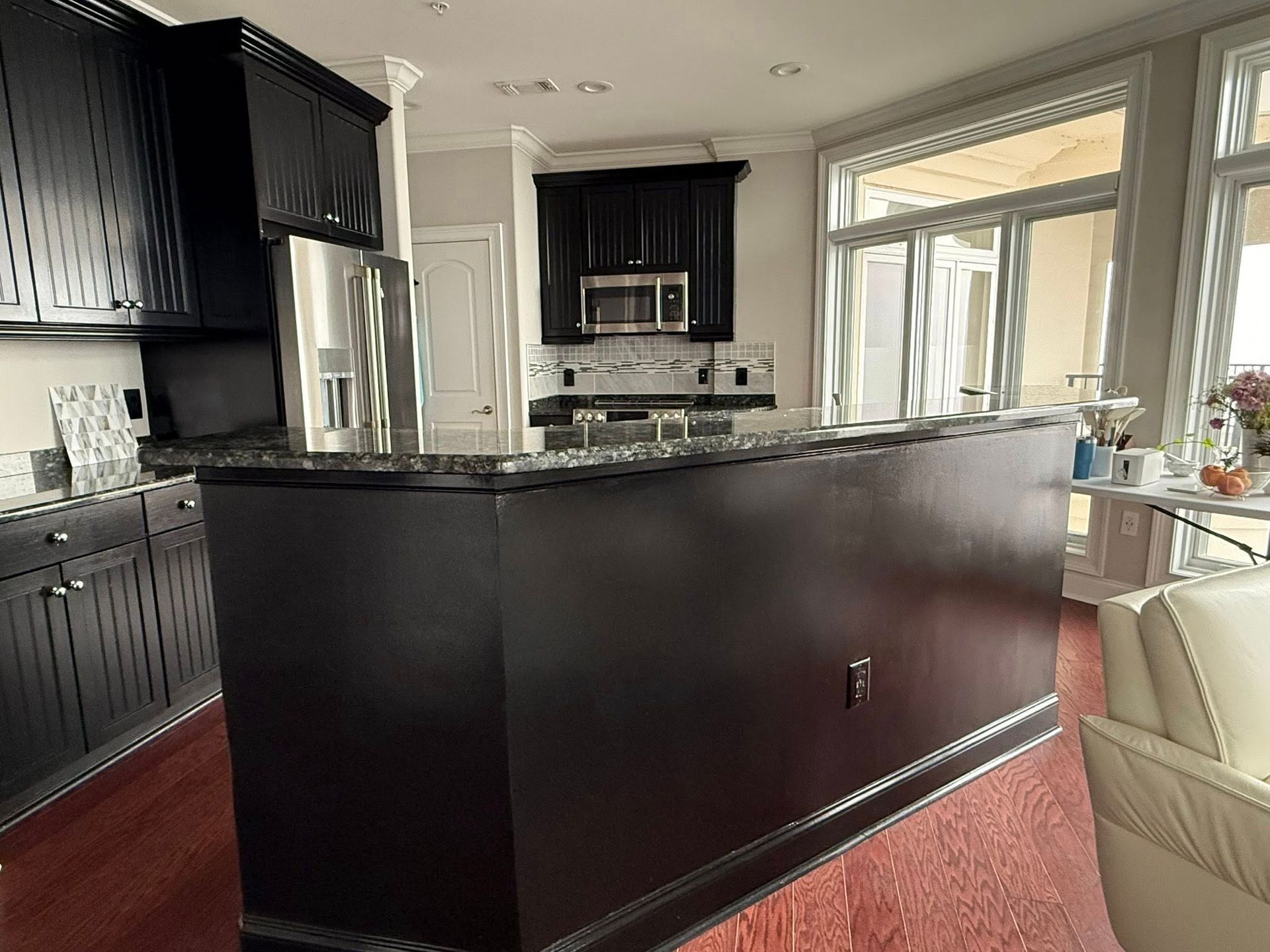 A kitchen with black cabinets and granite counter tops