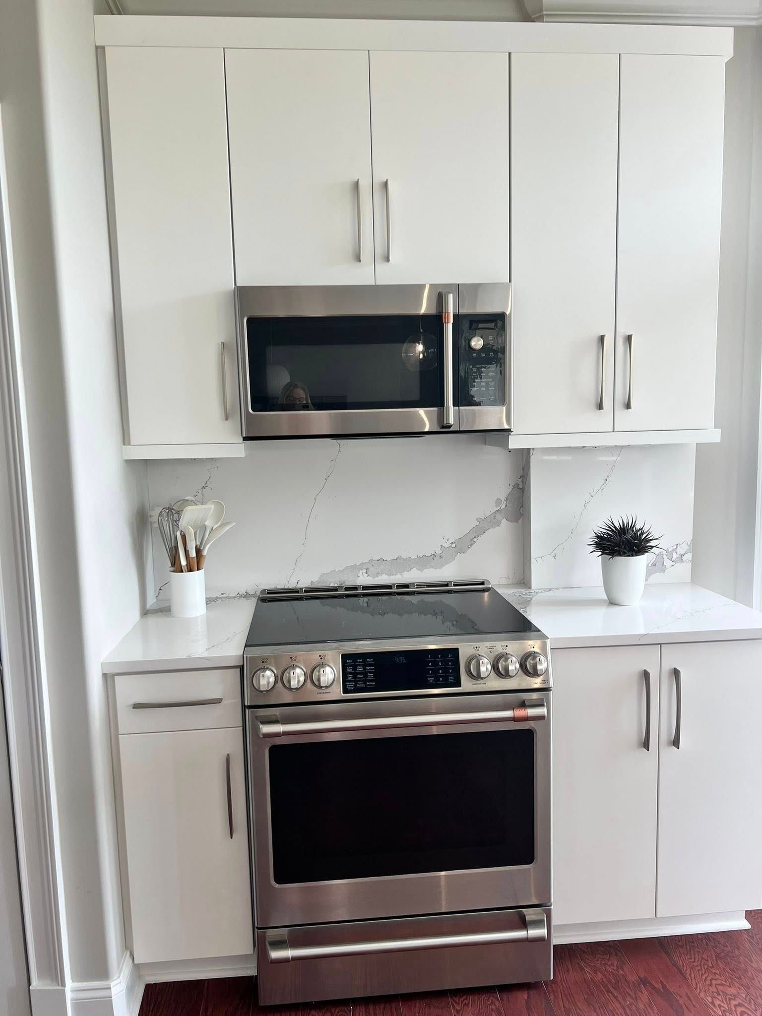 A kitchen with stainless steel appliances and white cabinets