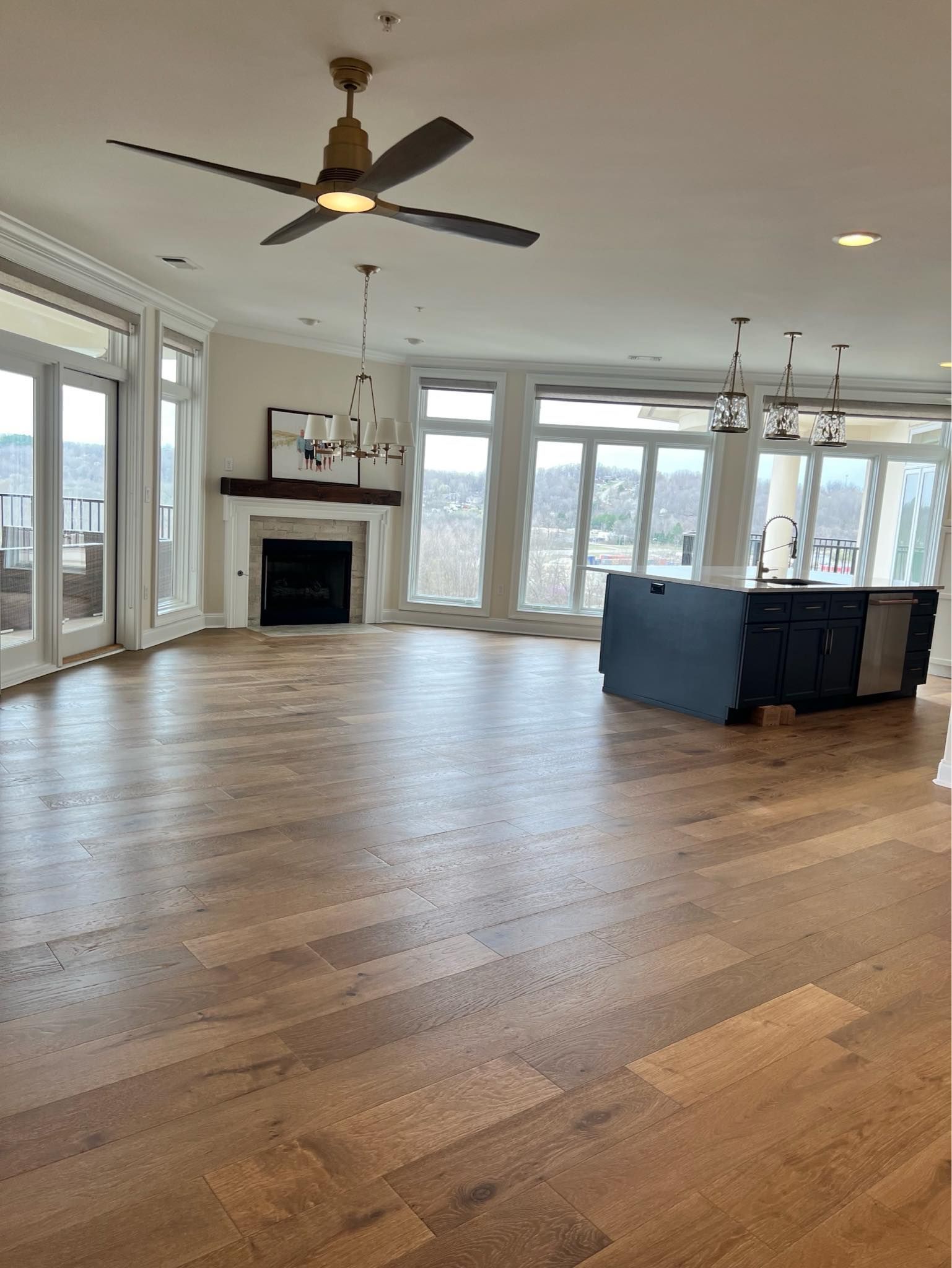 A large empty room with hardwood floors and a ceiling fan
