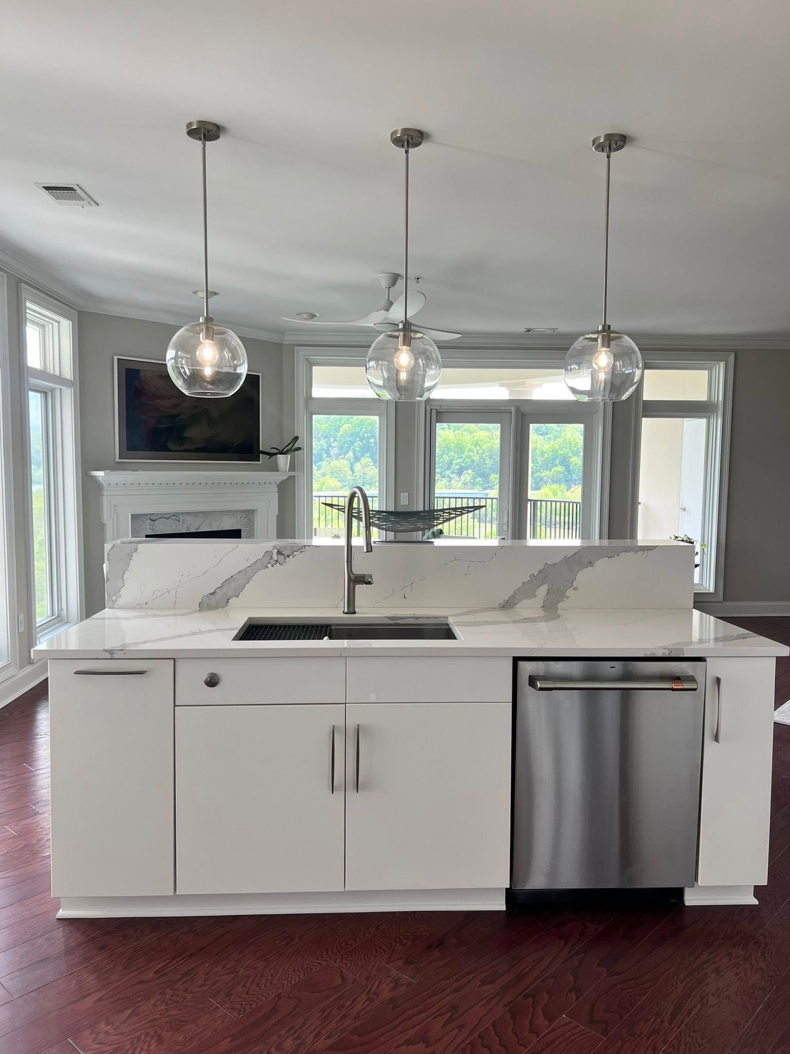 A kitchen with white cabinets, a sink, and a stainless steel dishwasher