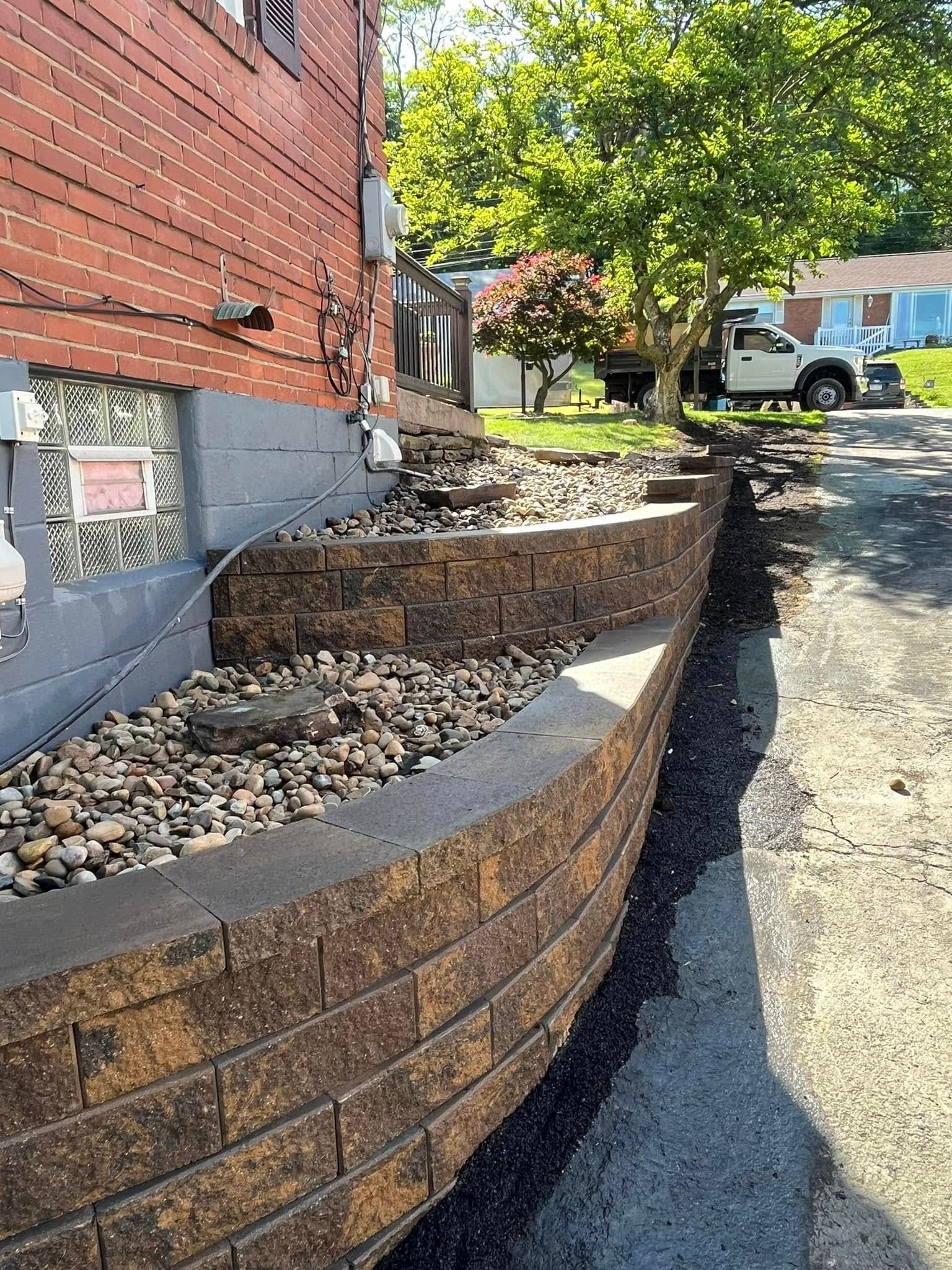 A brick wall is being built in front of a brick building.