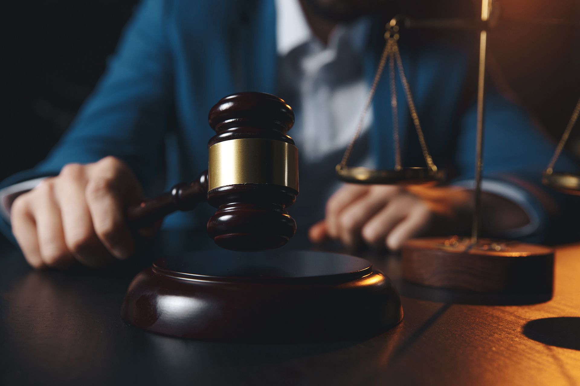 Two Men Are Sitting at a Table With a Gavel and Scales of Justice