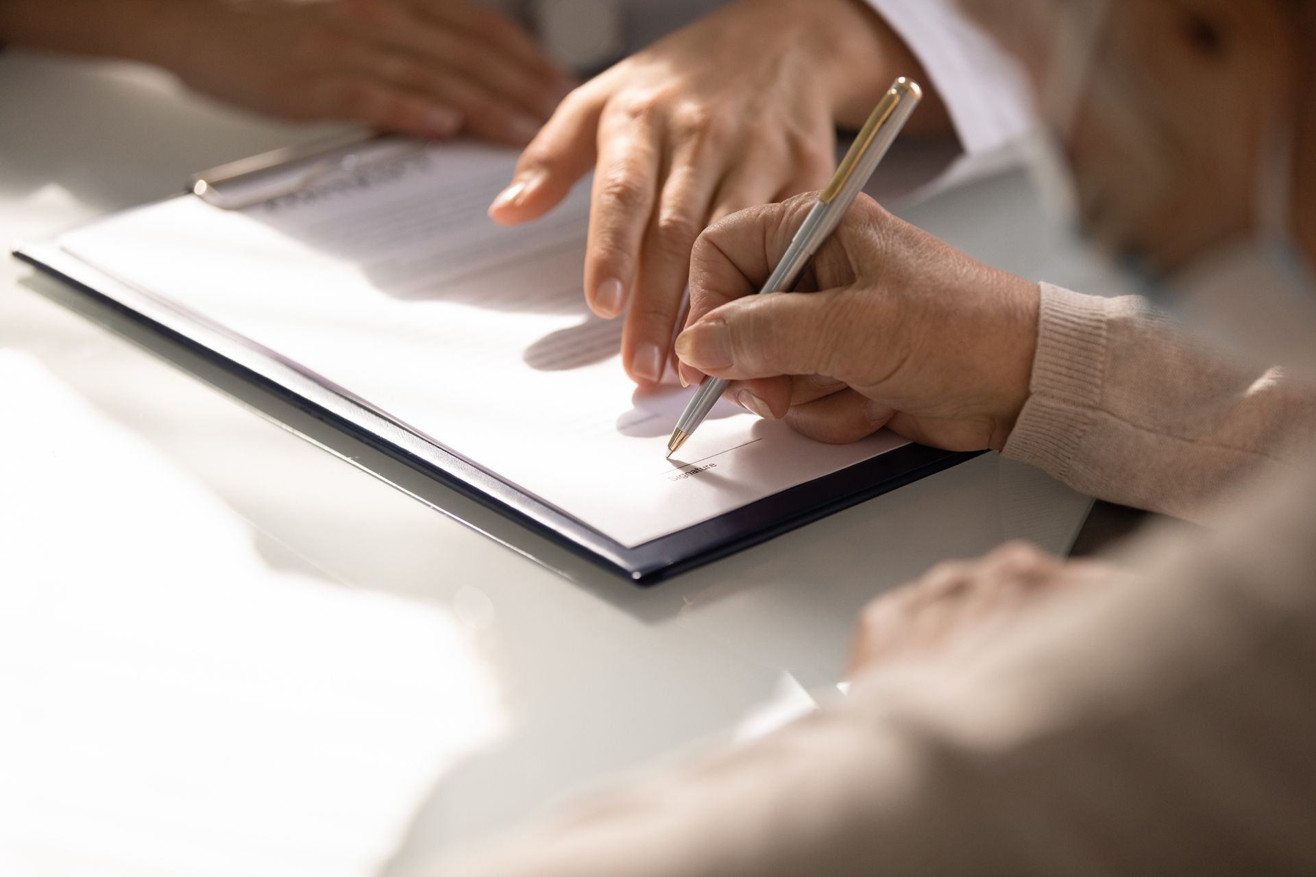 A Person is Writing on a Piece of Paper With a Pen