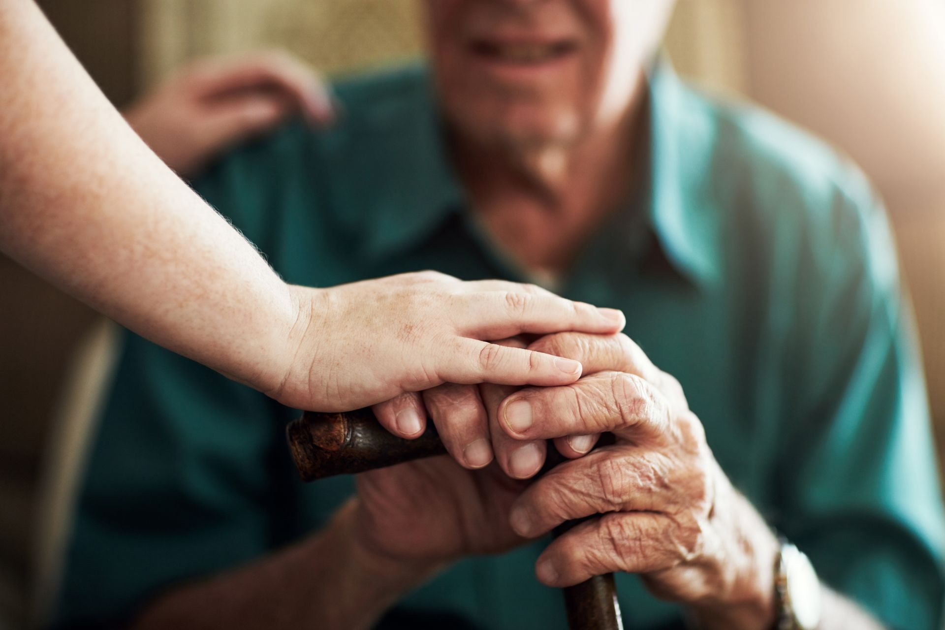 A Woman is Holding the Hand of an Elderly Man