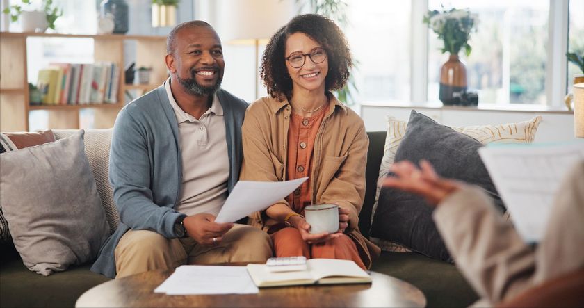A Man and a Woman Are Sitting on a Couch Holding Papers