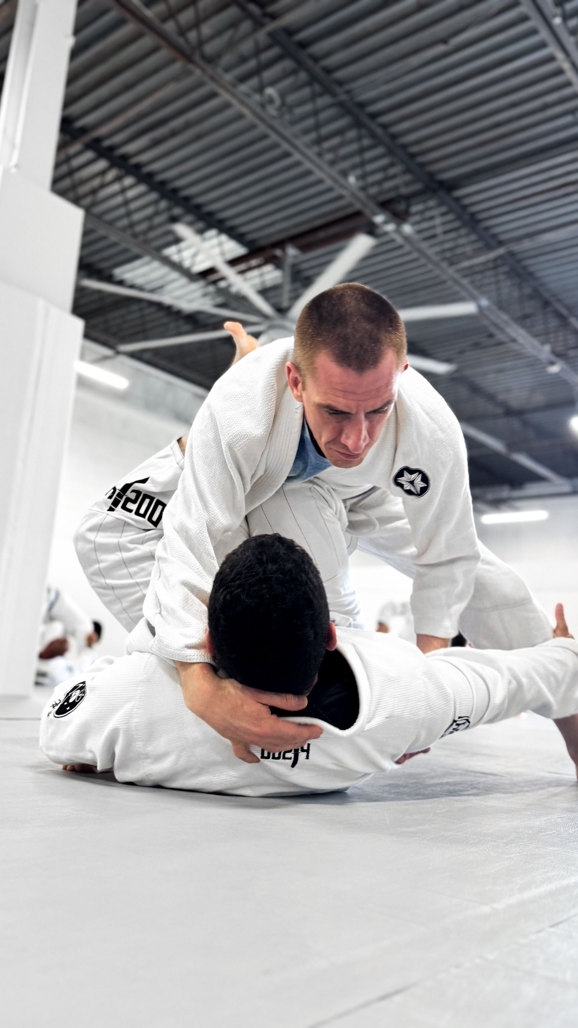 Adults drilling Brazilian Jiu Jitsu technique at Breathe Jiu Jitsu in Yaphank, NY to build fitness.