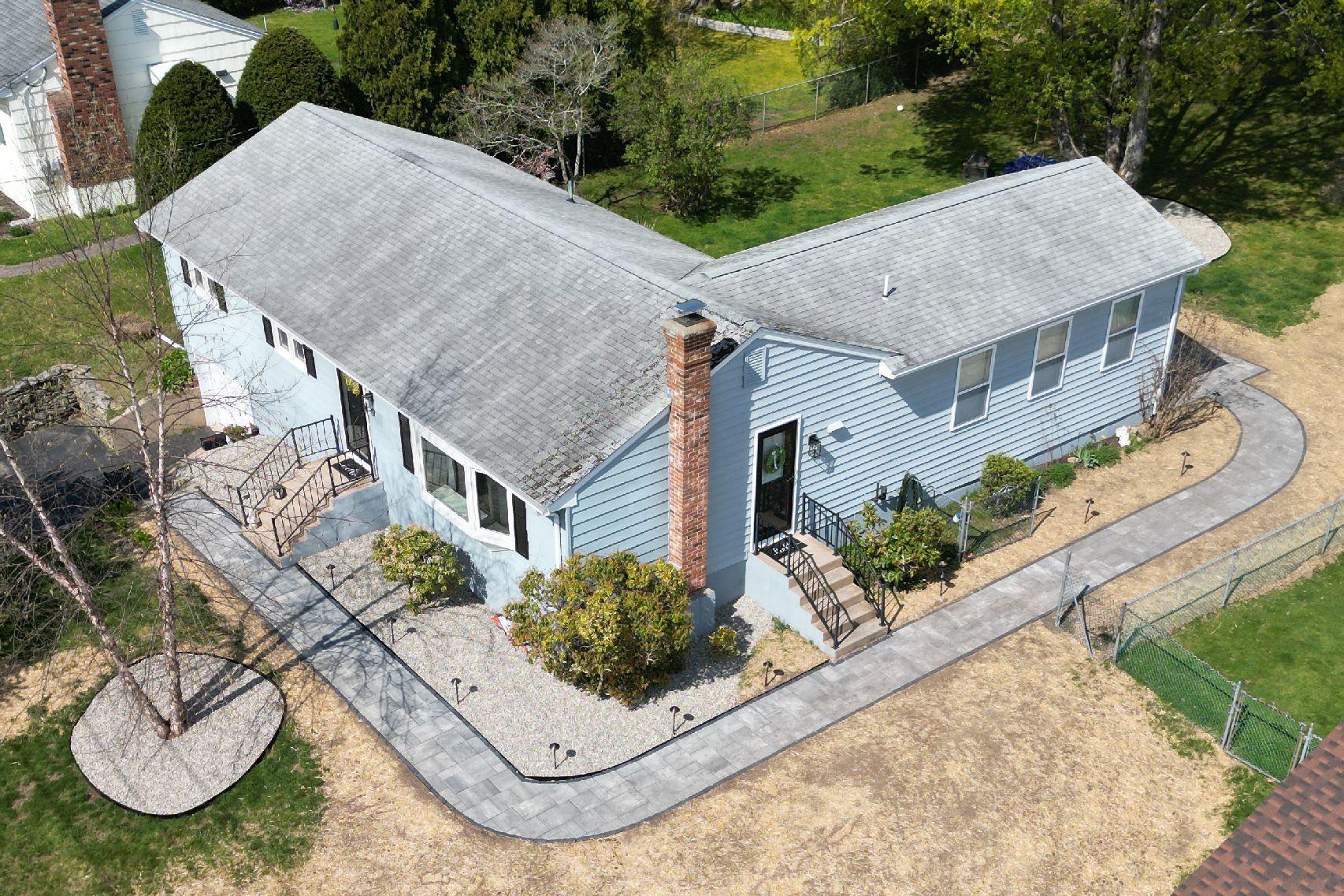A house with a metal roof and a large lawn in front of it.