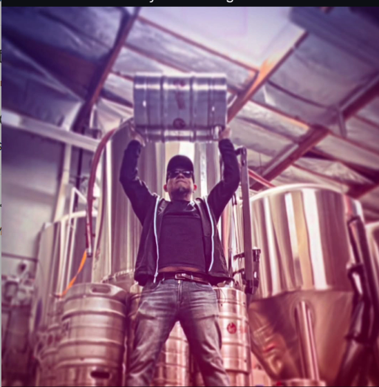 Man lifting a beer keg in a brewery.