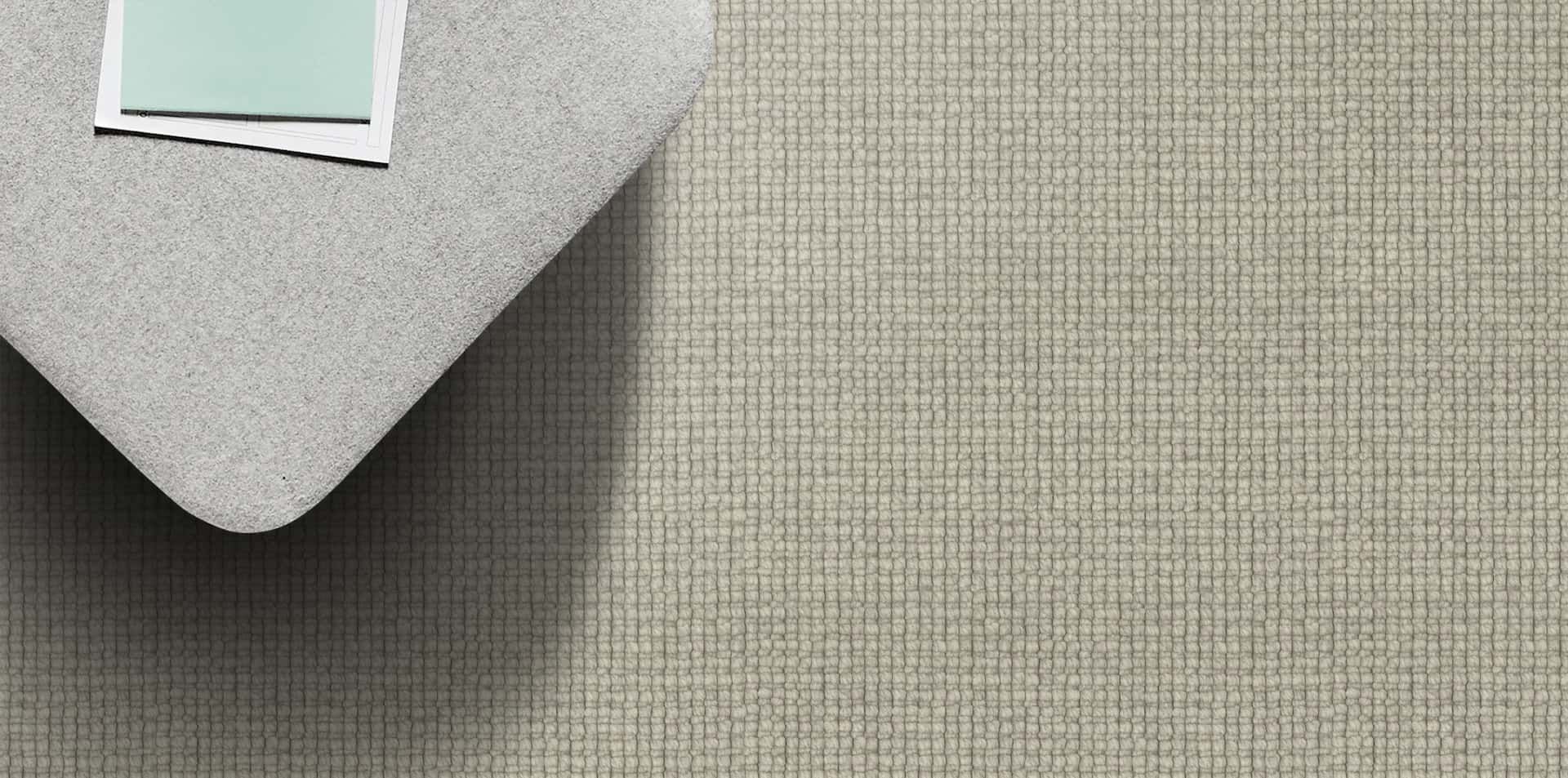 Gray fabric with square corner; small light blue paper on the fabric surface.