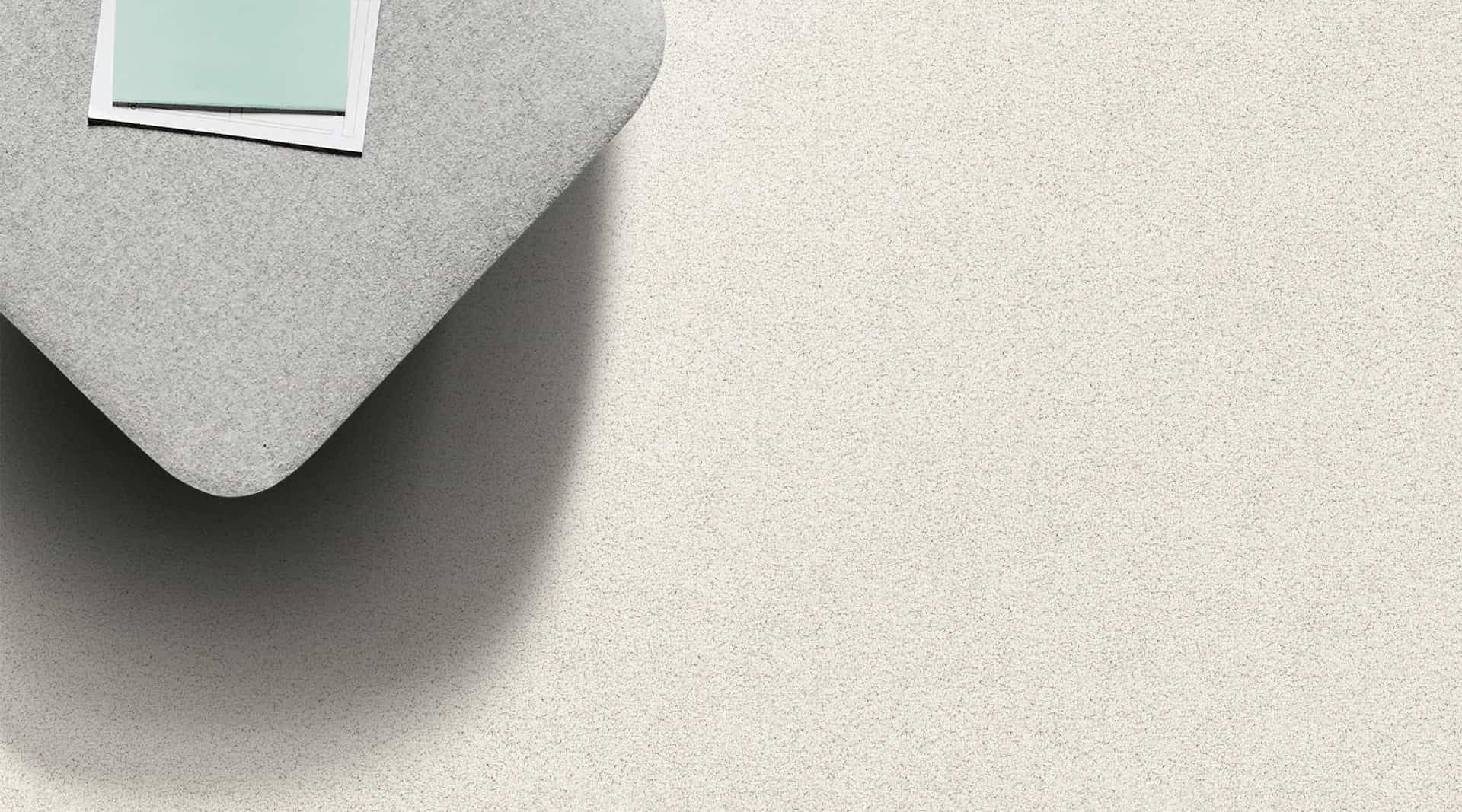 Corner of gray table with a photo, casting a shadow on a light textured surface.