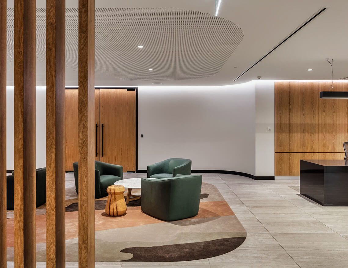 A Living Room with Green Chairs, a Table, and A Wooden Divider — Tony Di Milia Flooring in Unanderra, NSW