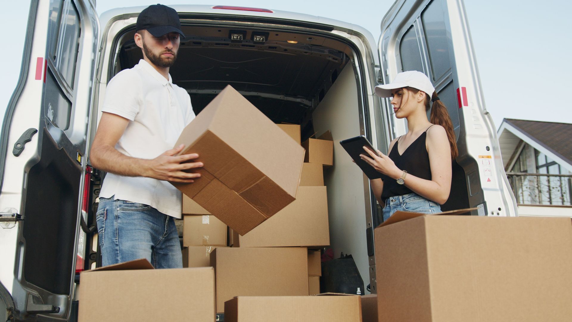 Professional movers unloading boxes from a van during commercial moving by Renton Movers Pros in Renton, WA