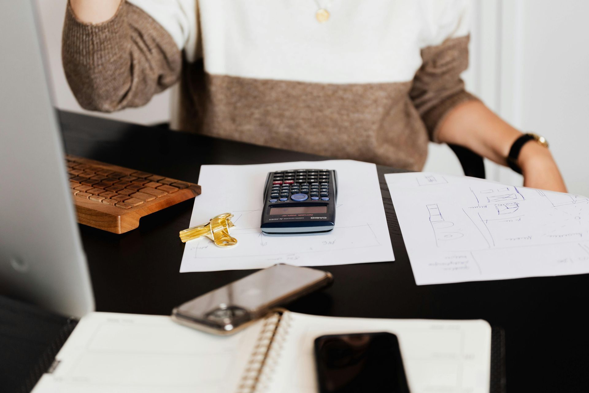 A person initiating proactive tax strategies at their desk with paperwork and a calculator.