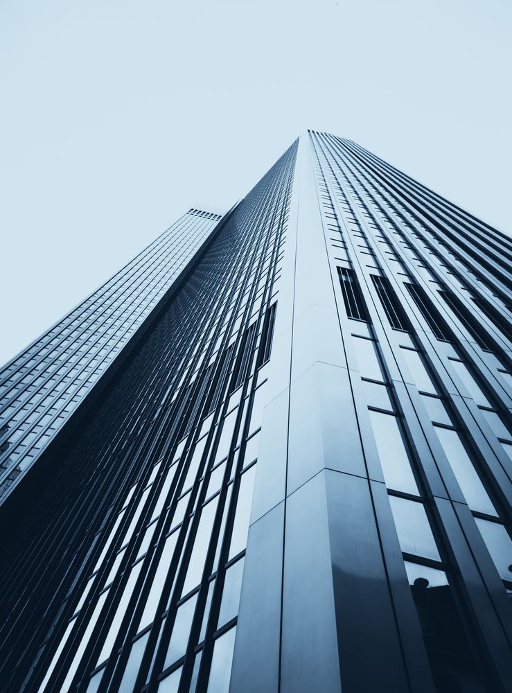 Upward view of modern corporate skyscraper symbolizing enterprise growth, finance, and industry.