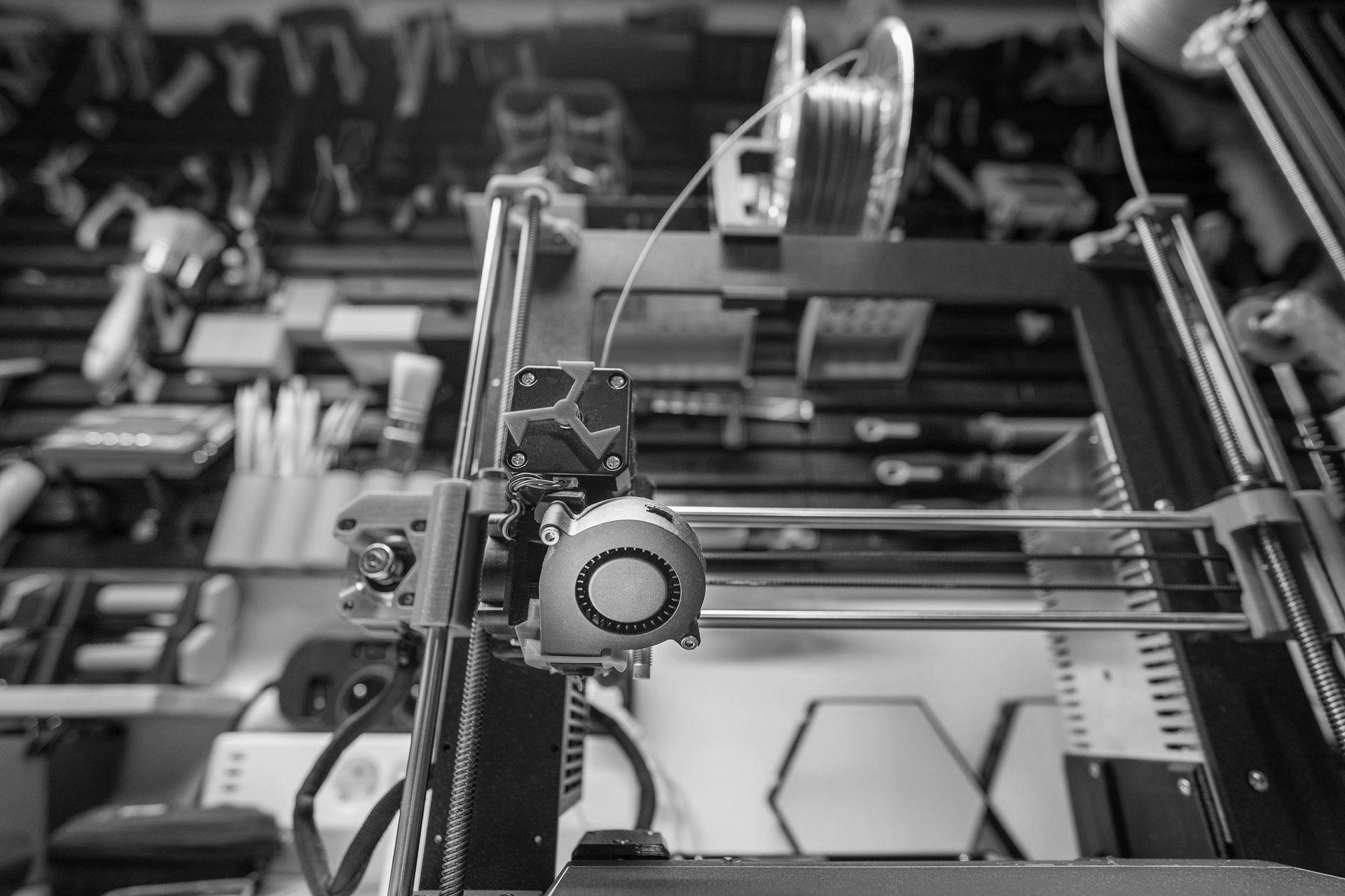 Close-up of a 3D printer in a workshop, highlighting advanced manufacturing and prototyping technology.