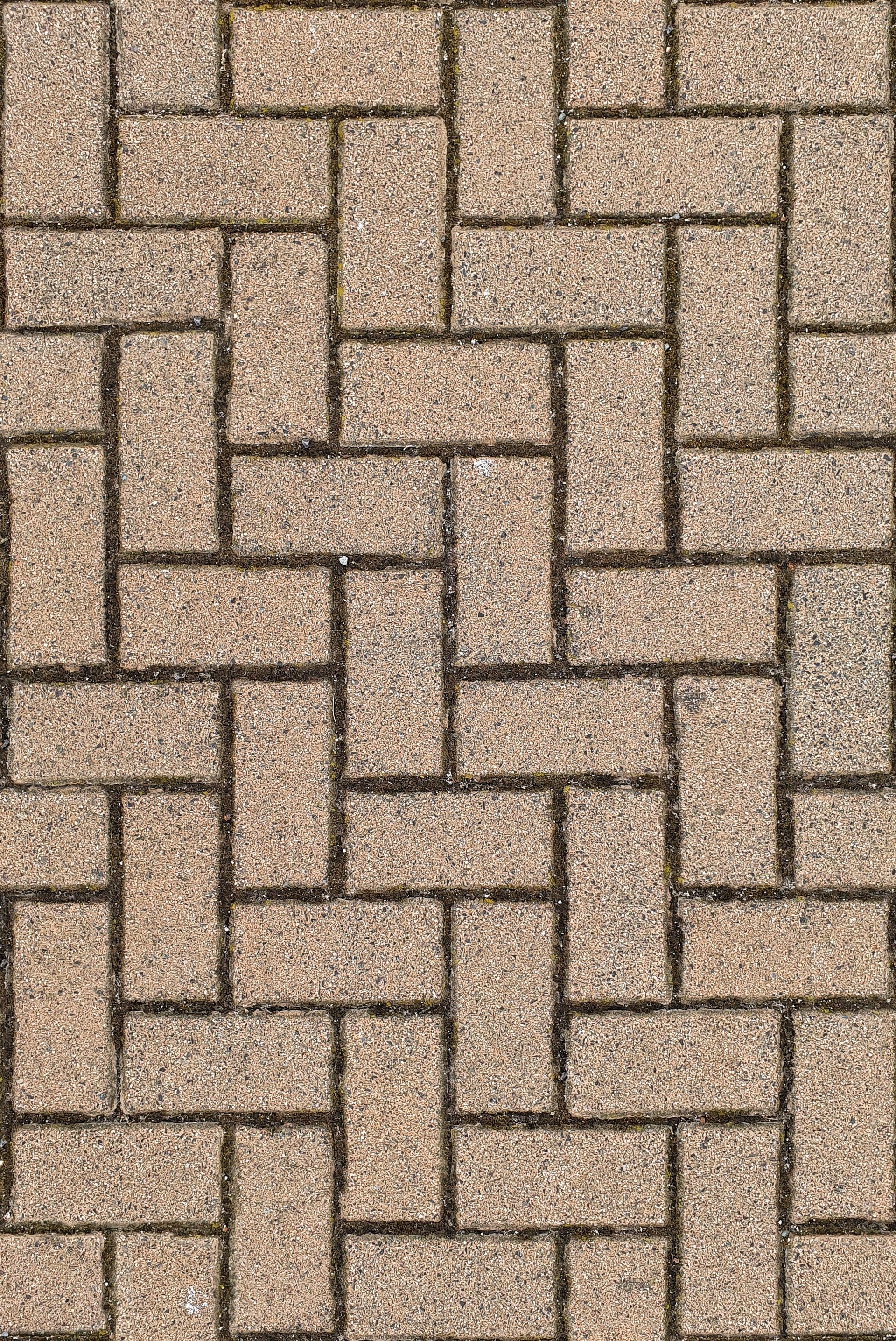 Tan interlocking brick or paver pattern with dark grout lines
