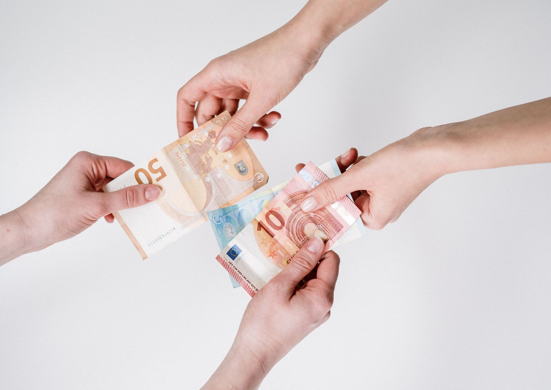 Hands exchanging euro banknotes on a white background
