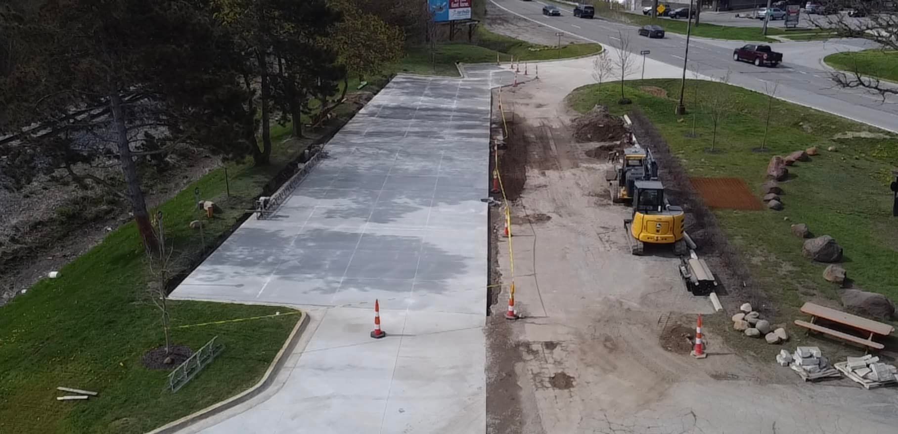Construction site with a freshly poured concrete slab and heavy machinery.