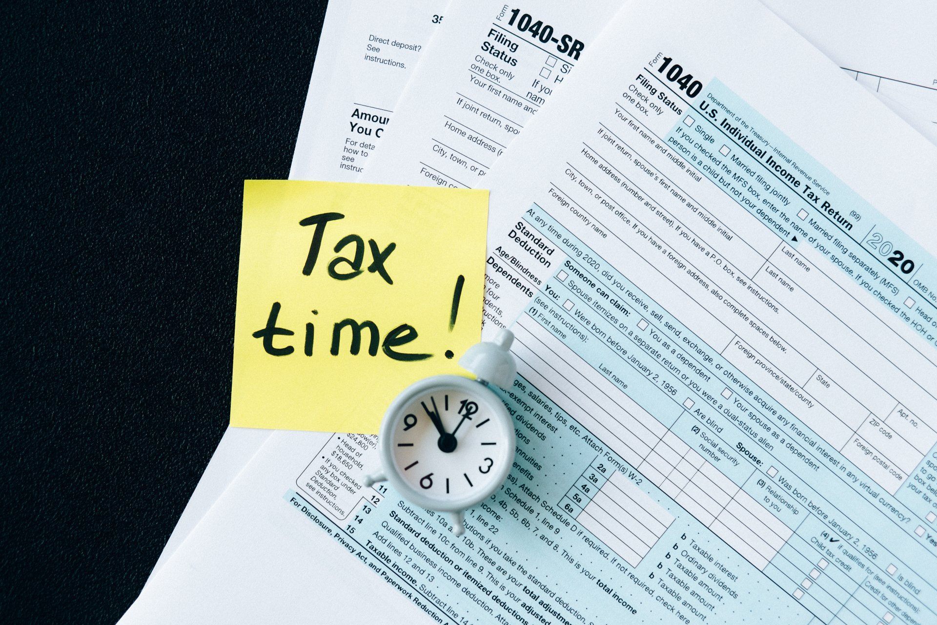 A sticky note that says tax time next to a clock