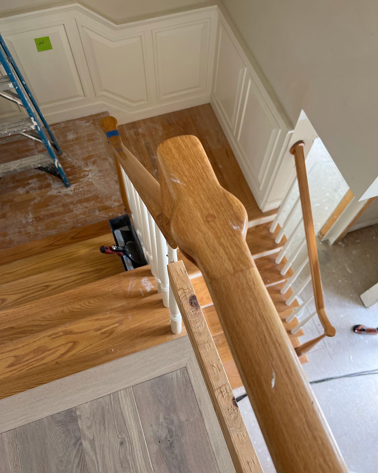 An aerial view of a wooden staircase with a ladder in the background.