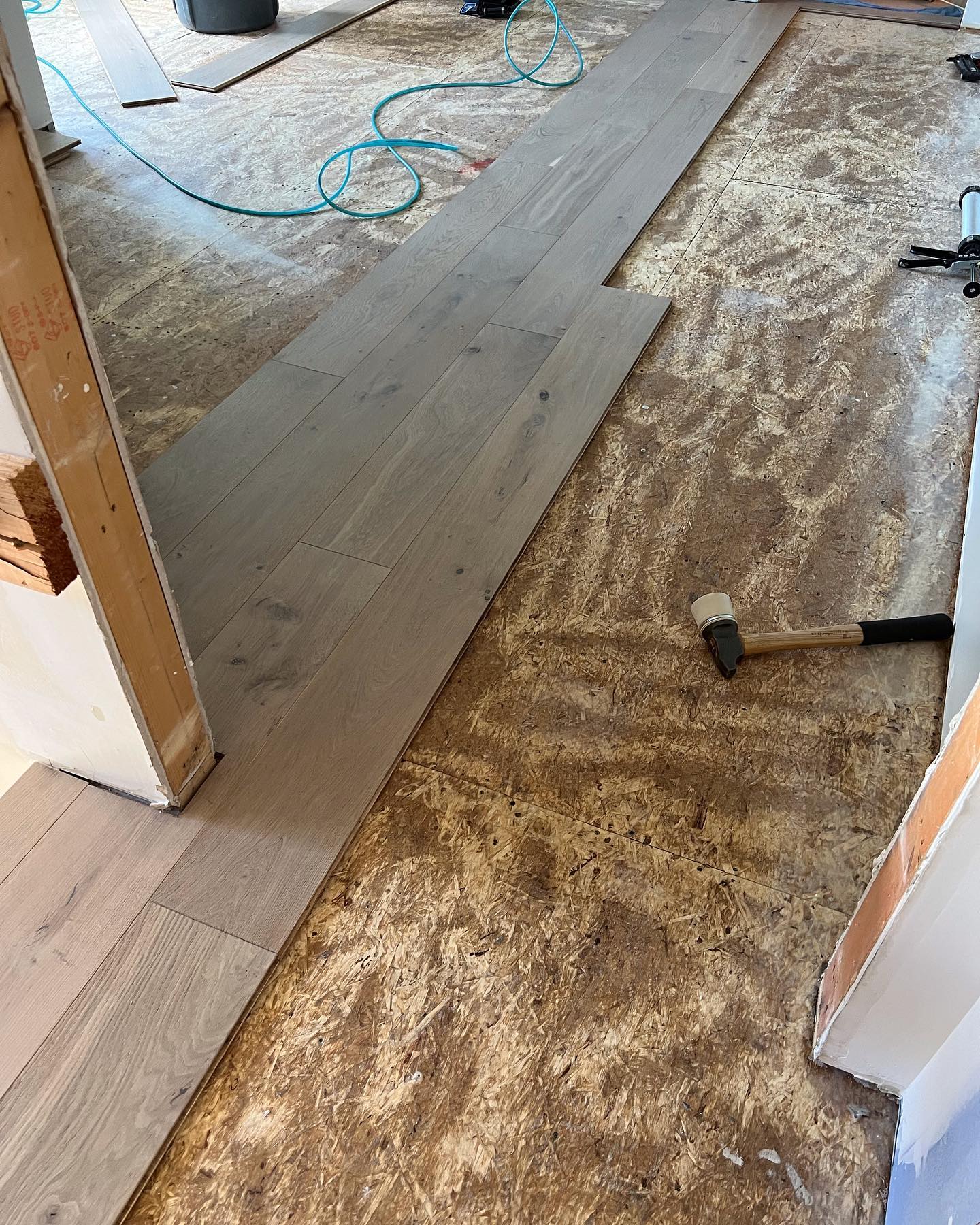 A wooden floor is being installed in a room.