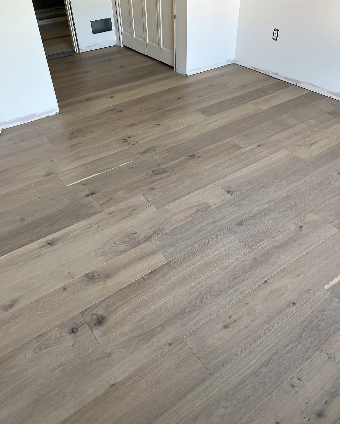 A room with a wooden floor and white walls.