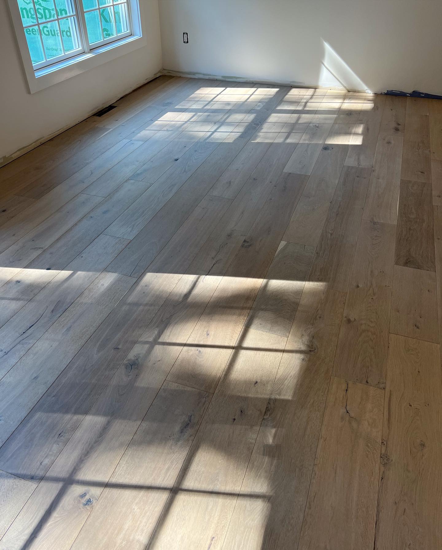 A room with a wooden floor and a lot of windows