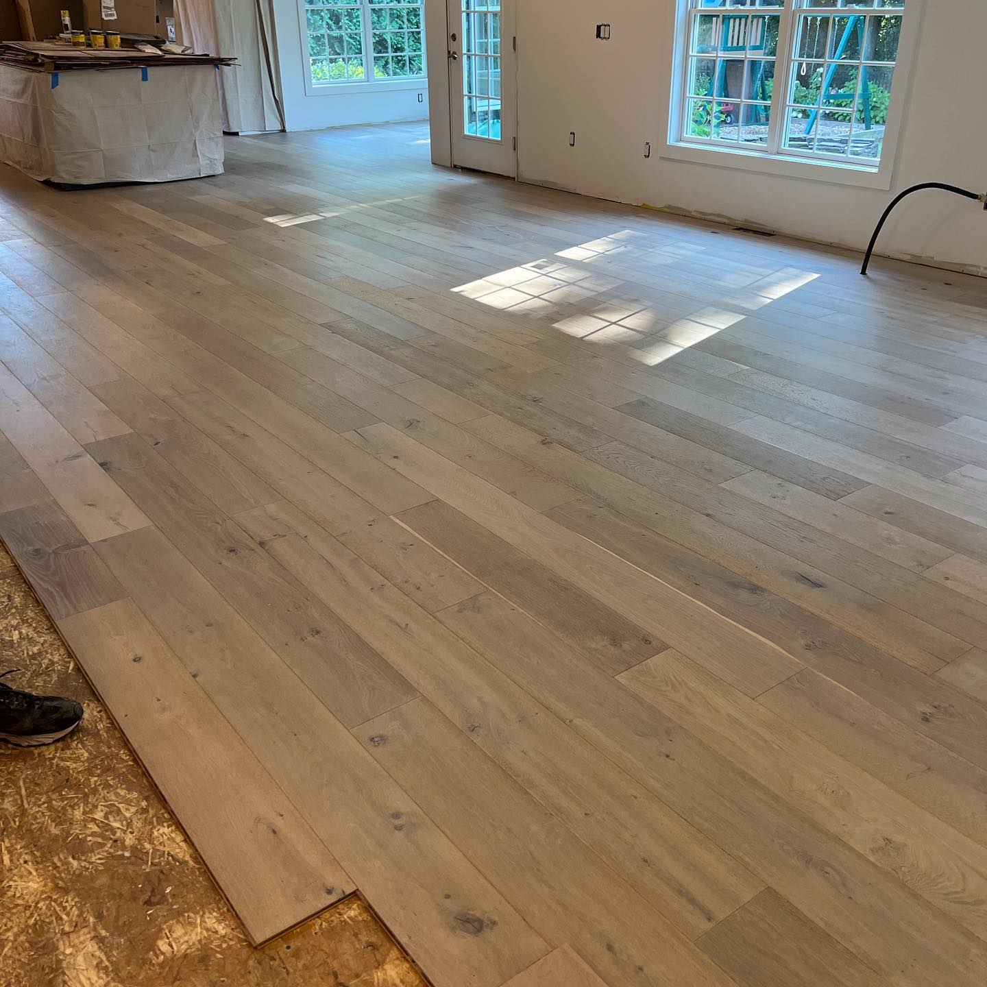 A room with a wooden floor and a lot of windows.