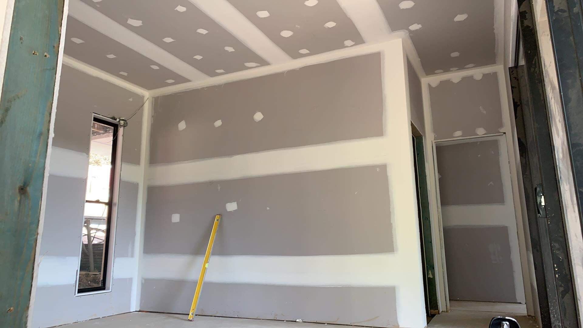 A Room With Drywall on The Walls and a Yellow Ruler on The Floor — Plaster Installation in Bensville, NSW
