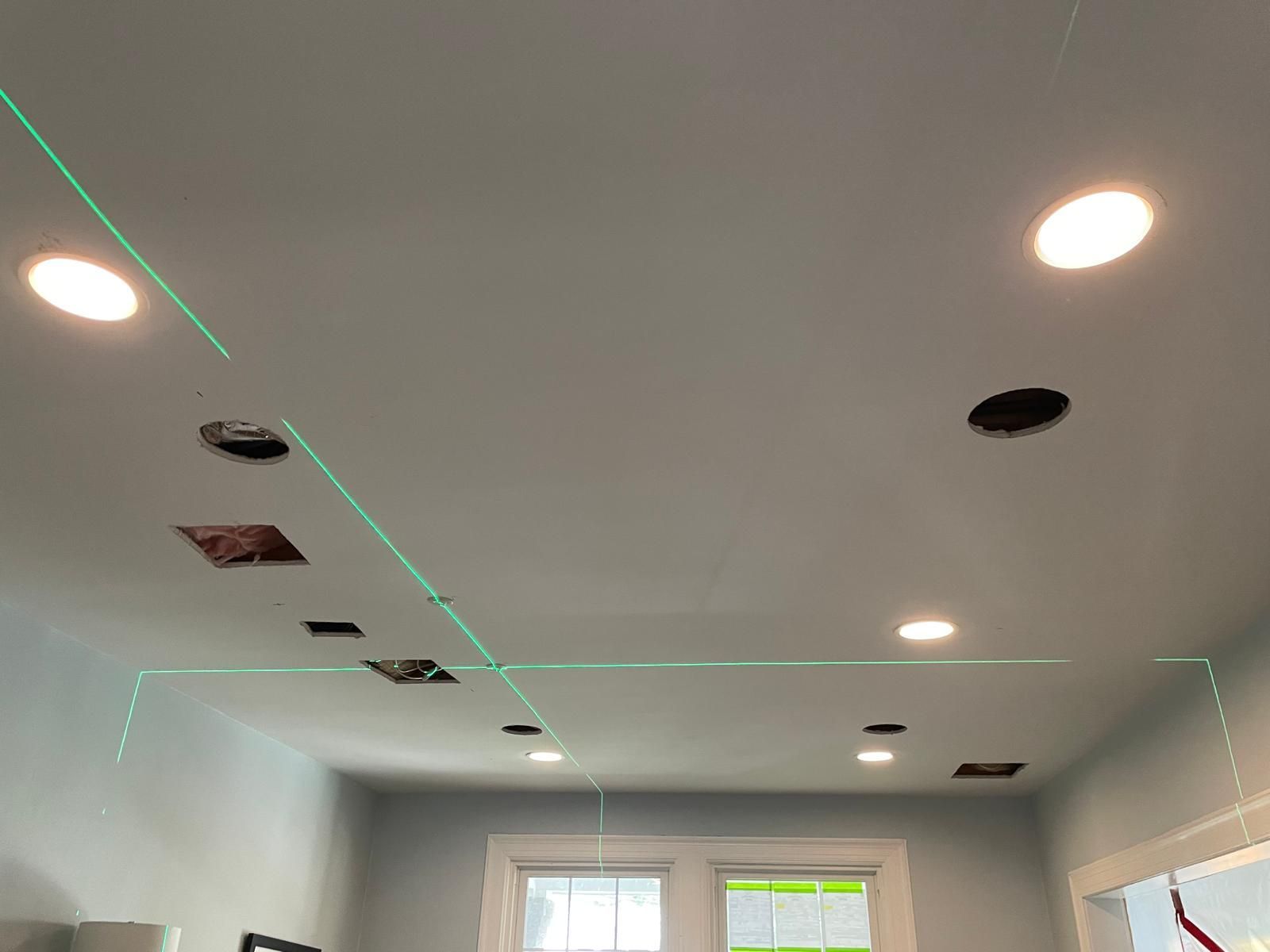 Ceiling with recessed lights and ventilation cutouts in a room under construction