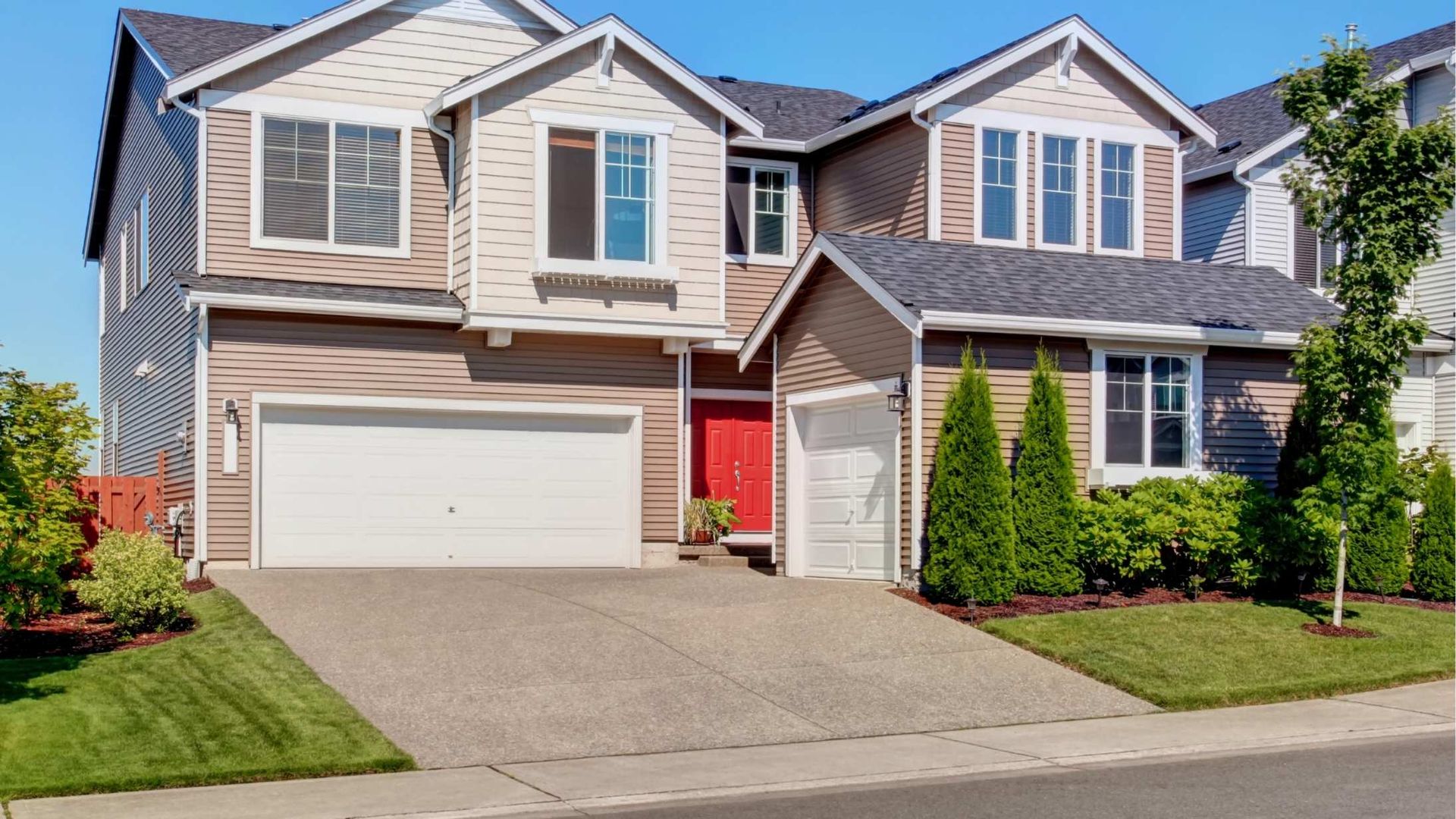 Suburban two-story house with beige siding, red front door, white garage, and a concrete driveway
