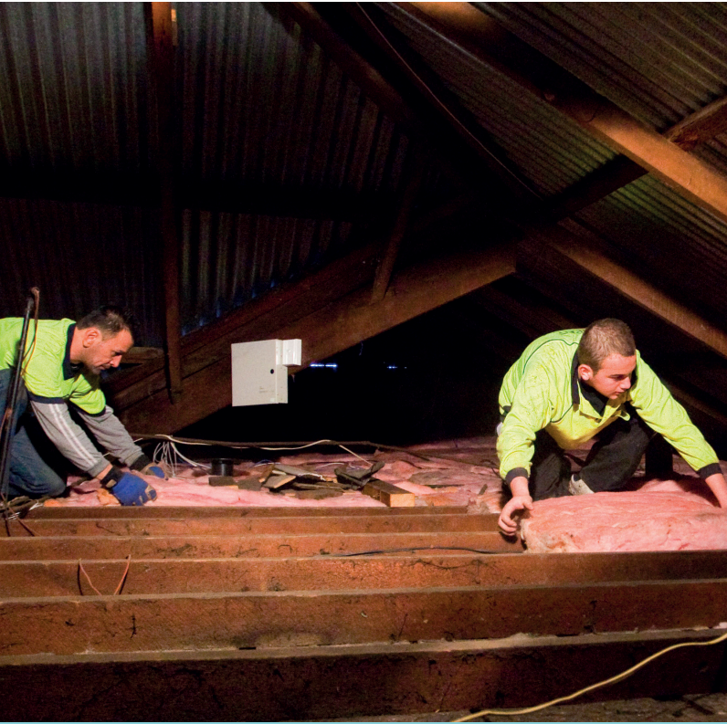 Two Men In A Roof Cavity Installing Pink Batts Insulation — Austral Insulation In Toormina, NSW