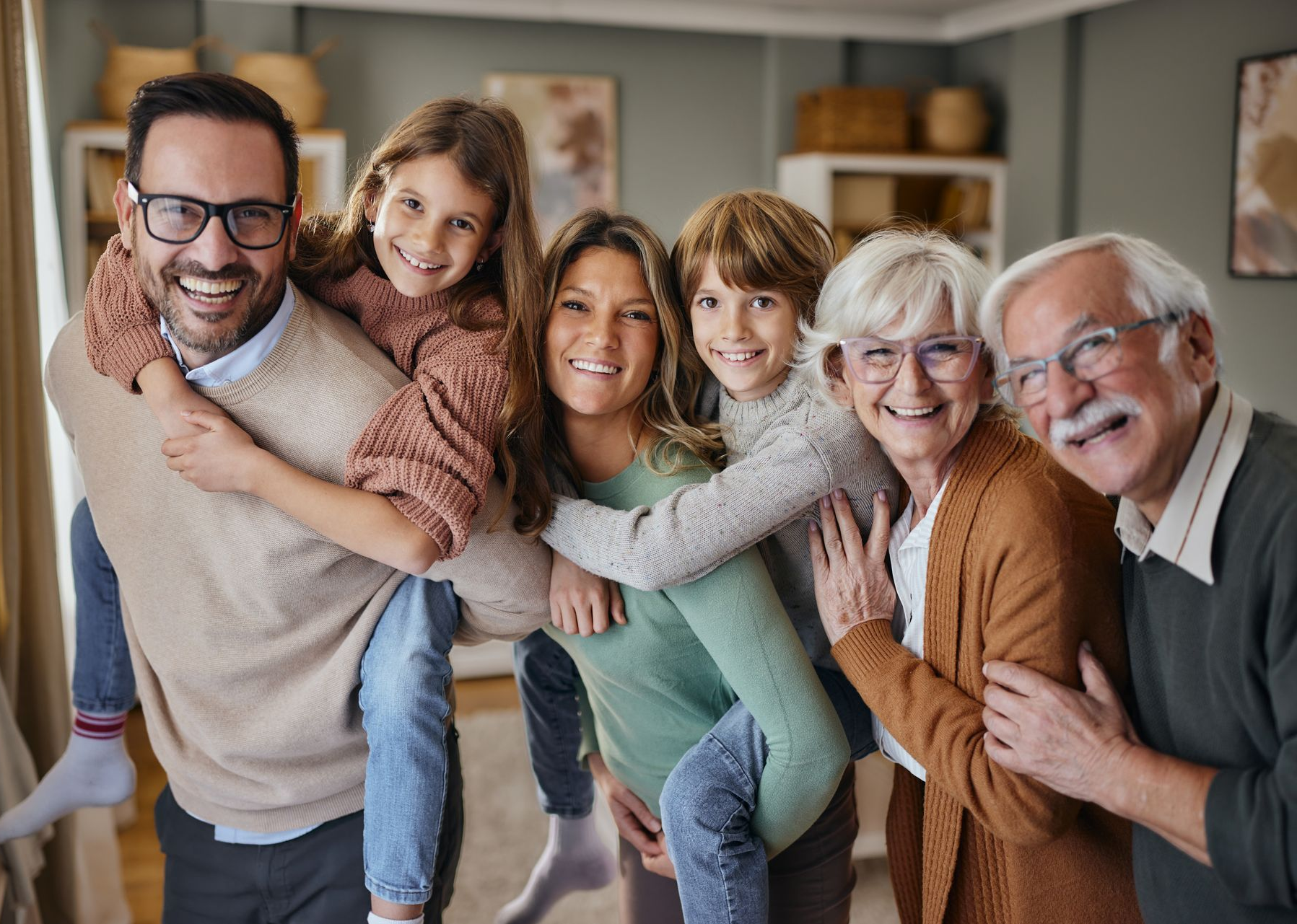 Family smiling and hugging together indoors in a cozy living room