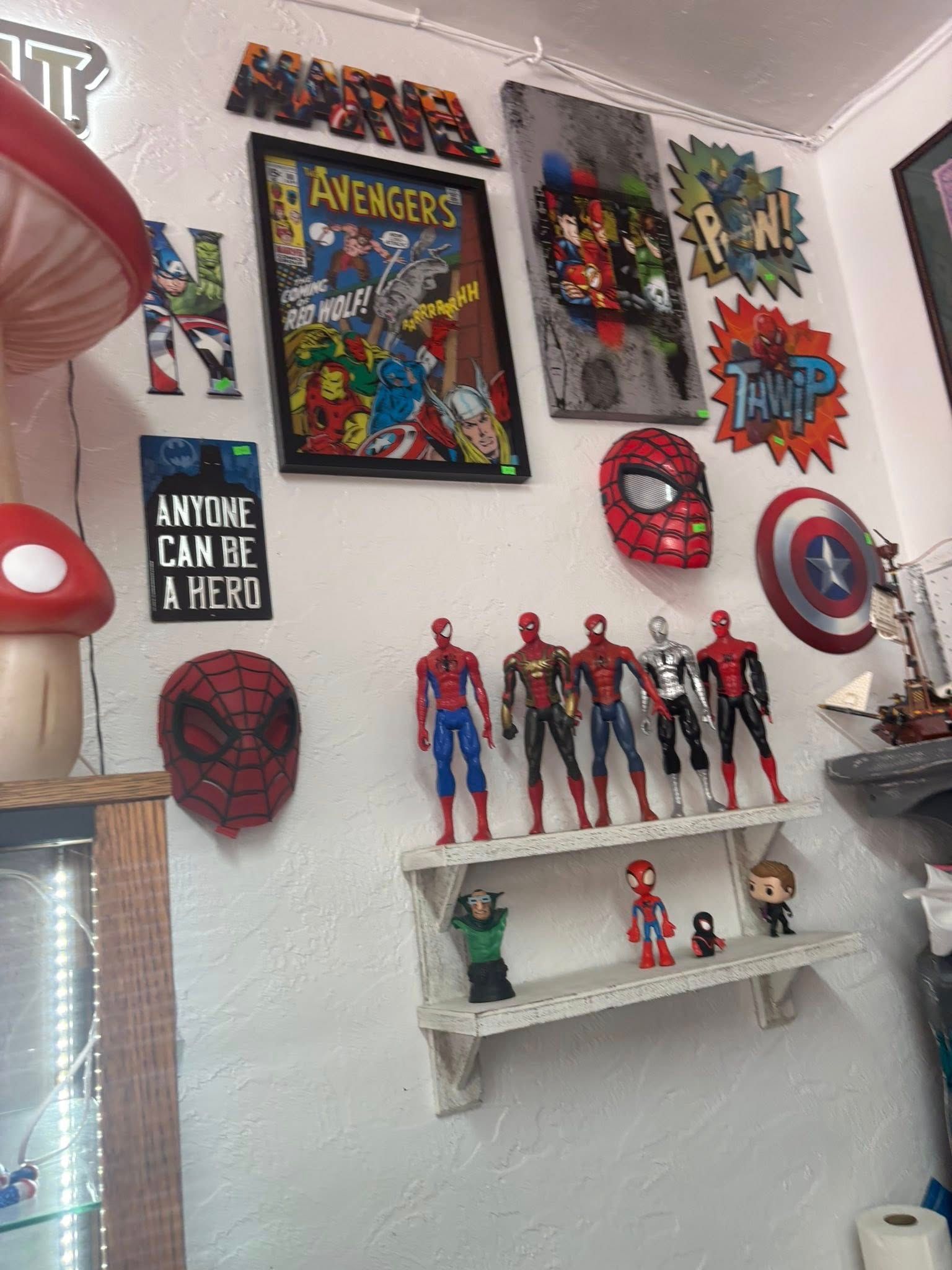 Wall decor with comic book covers, figurines, and superhero-themed art.