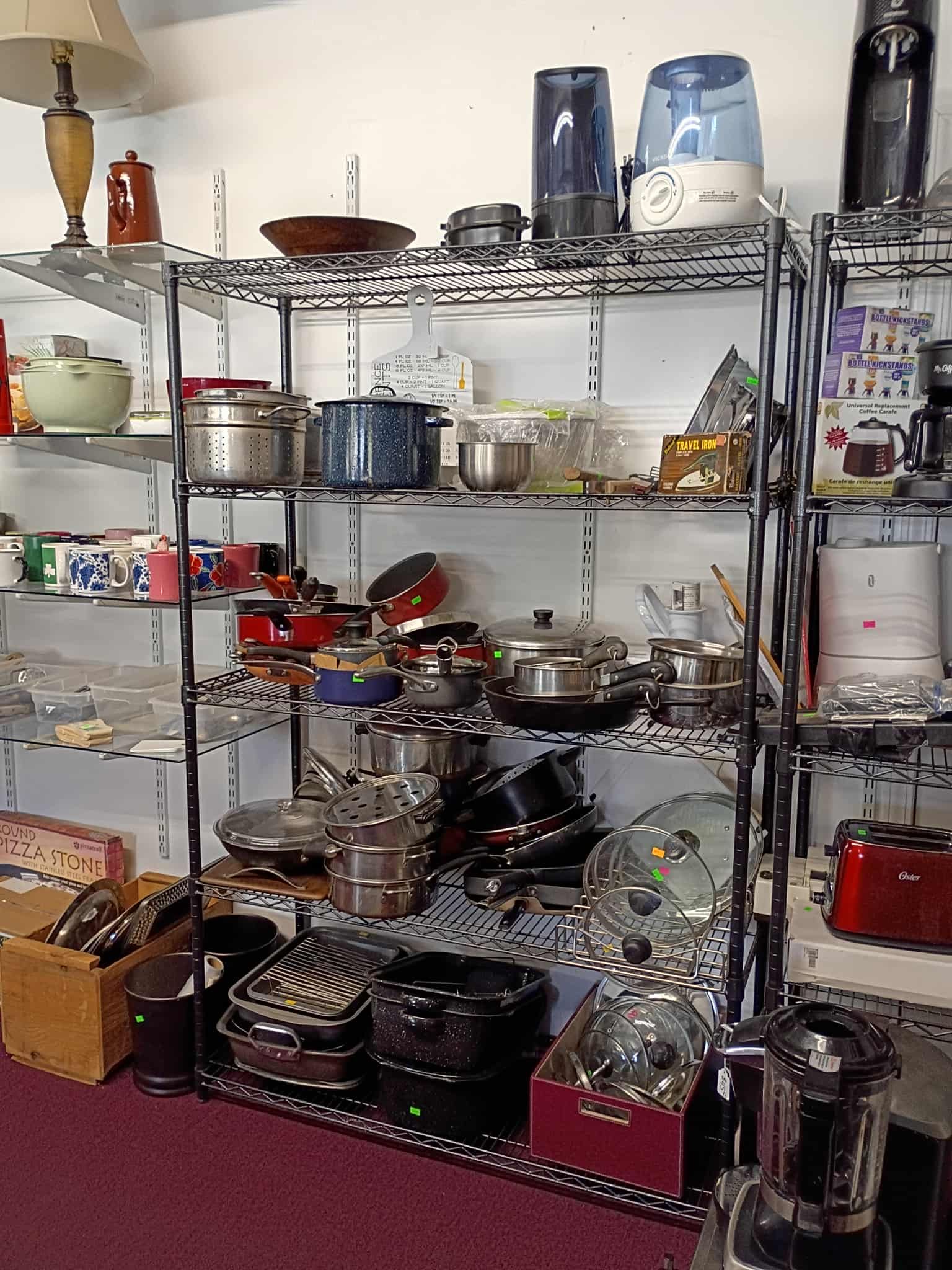Shelves filled with various kitchenware and appliances in a store setting