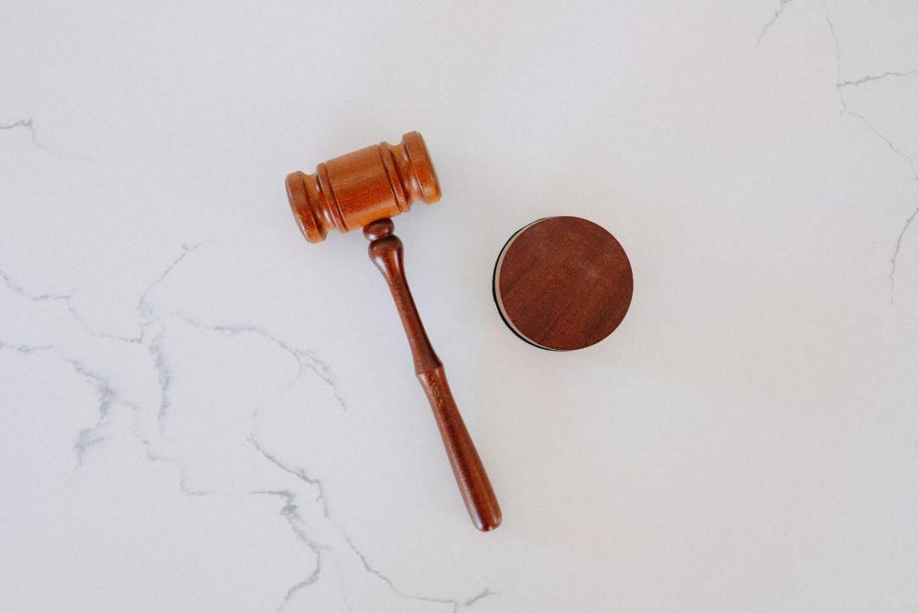 Wooden gavel and block on a white marble surface.