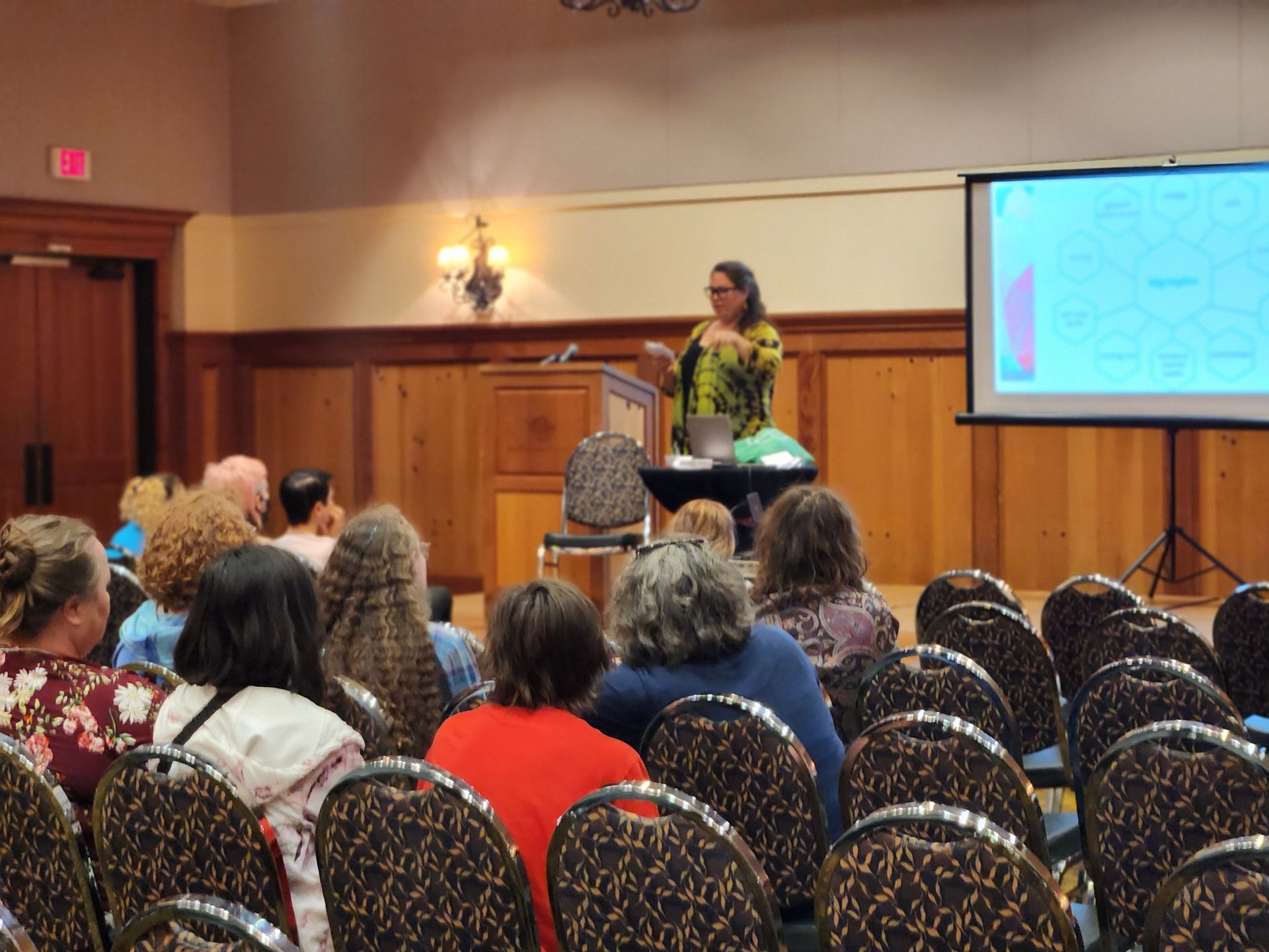 A woman is giving a presentation to a group of people in a conference room.