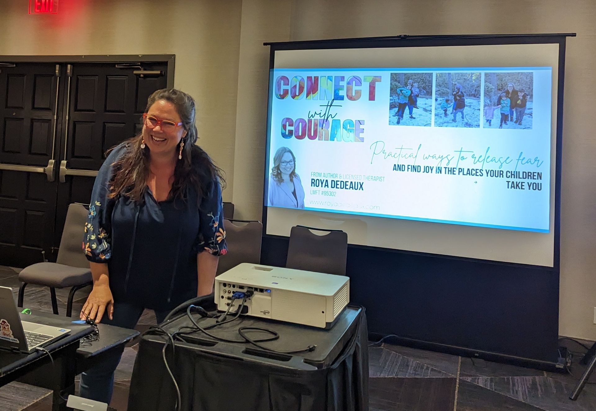 A woman is standing in front of a projector screen that says connect the course