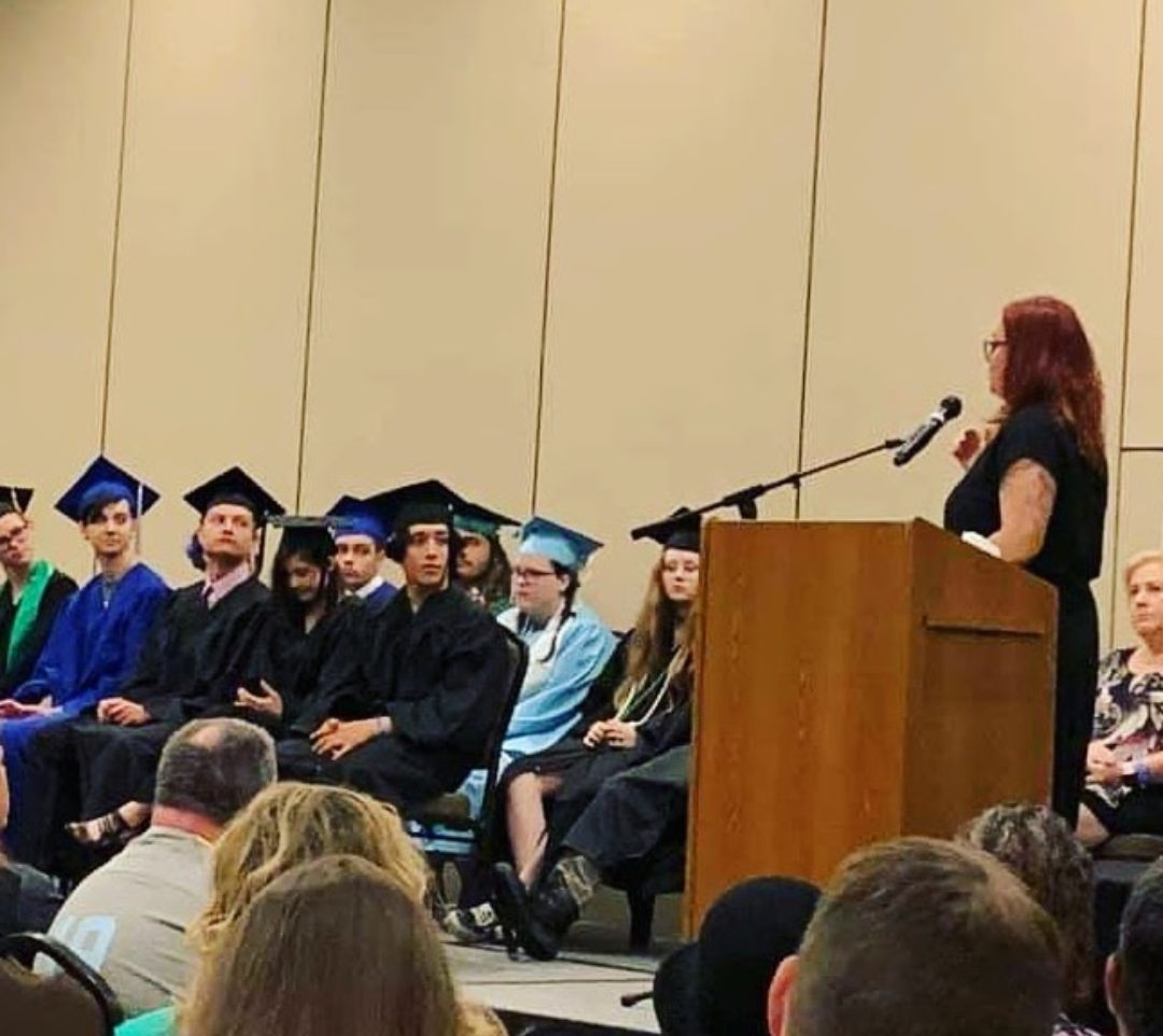 A woman is giving a speech at a graduation ceremony